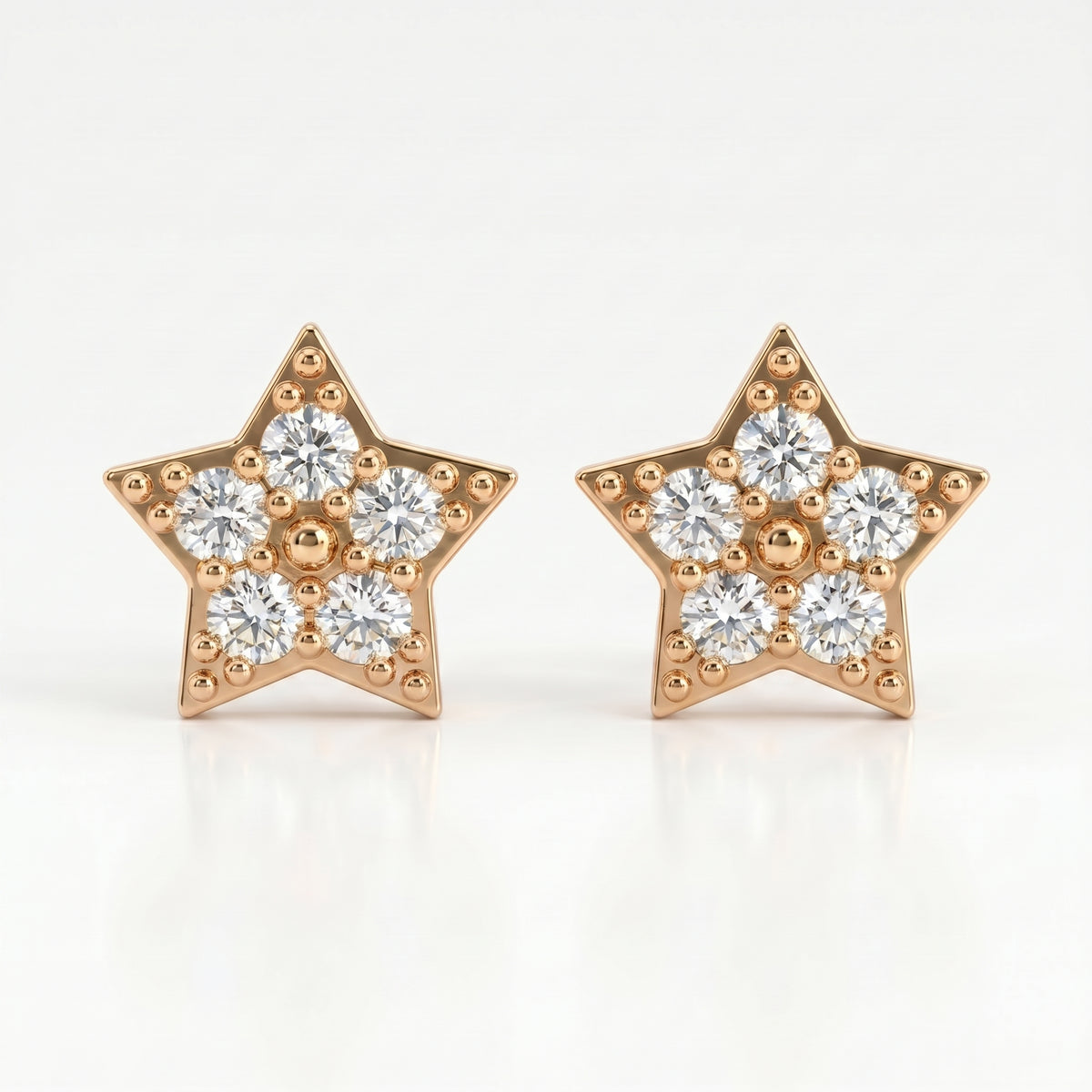 Gold star-shaped diamond stud earrings with pavé stones on white background, minimalist luxury jewelry design