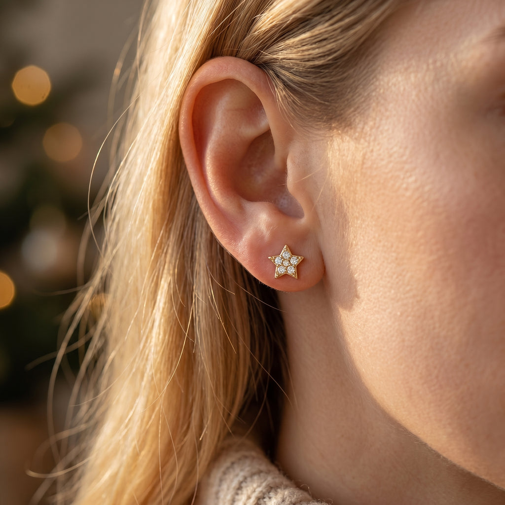 Close-up side profile of gold star stud earrings showing pavé setting and polished fine jewelry craftsmanship