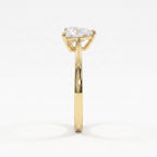 Side profile of a yellow gold solitaire engagement ring showcasing a raised three-prong triangle diamond setting.