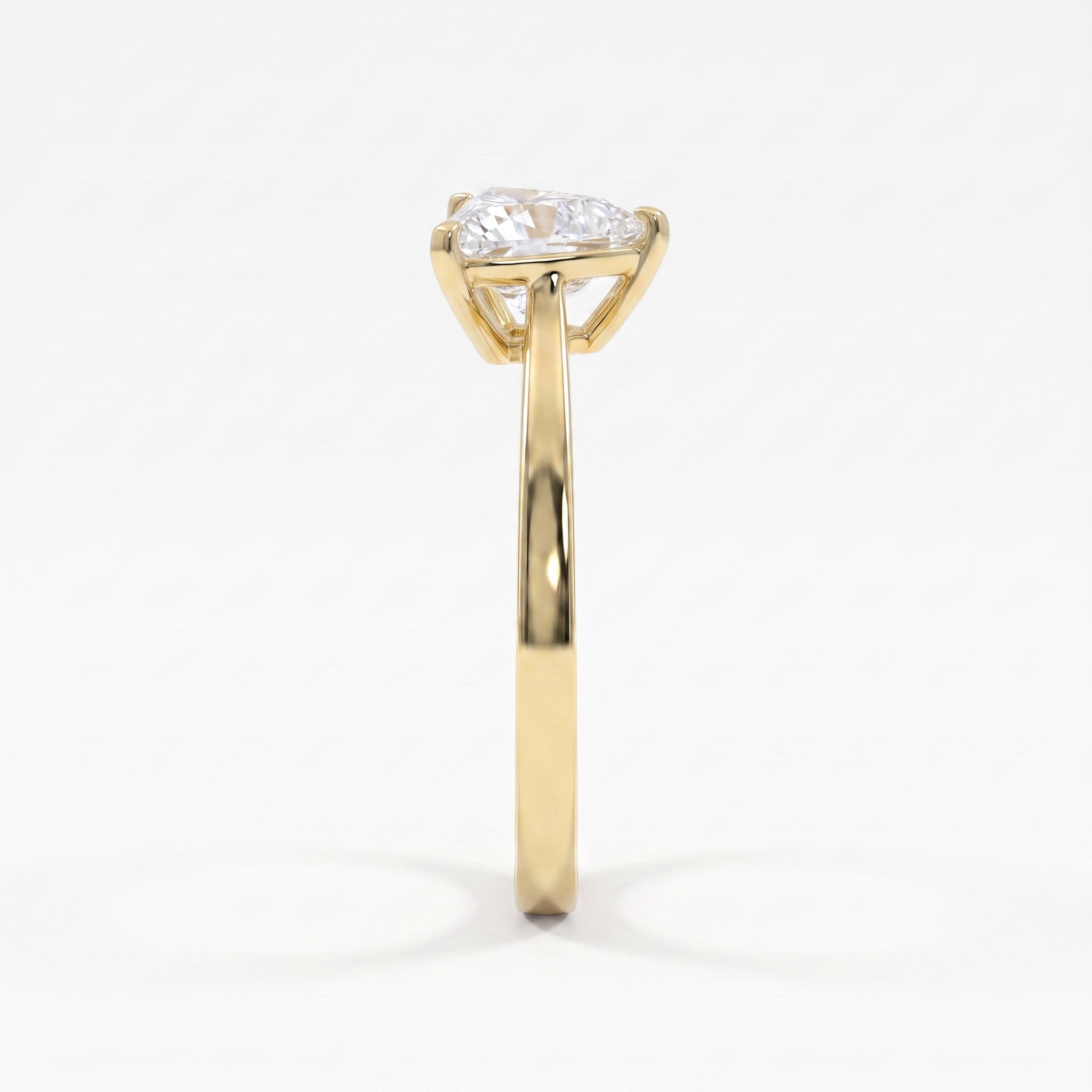 Side profile of a yellow gold solitaire engagement ring showcasing a raised three-prong triangle diamond setting.