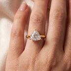 Yellow gold triangle cut solitaire engagement ring worn on hand in natural light for an elegant luxury lifestyle look.