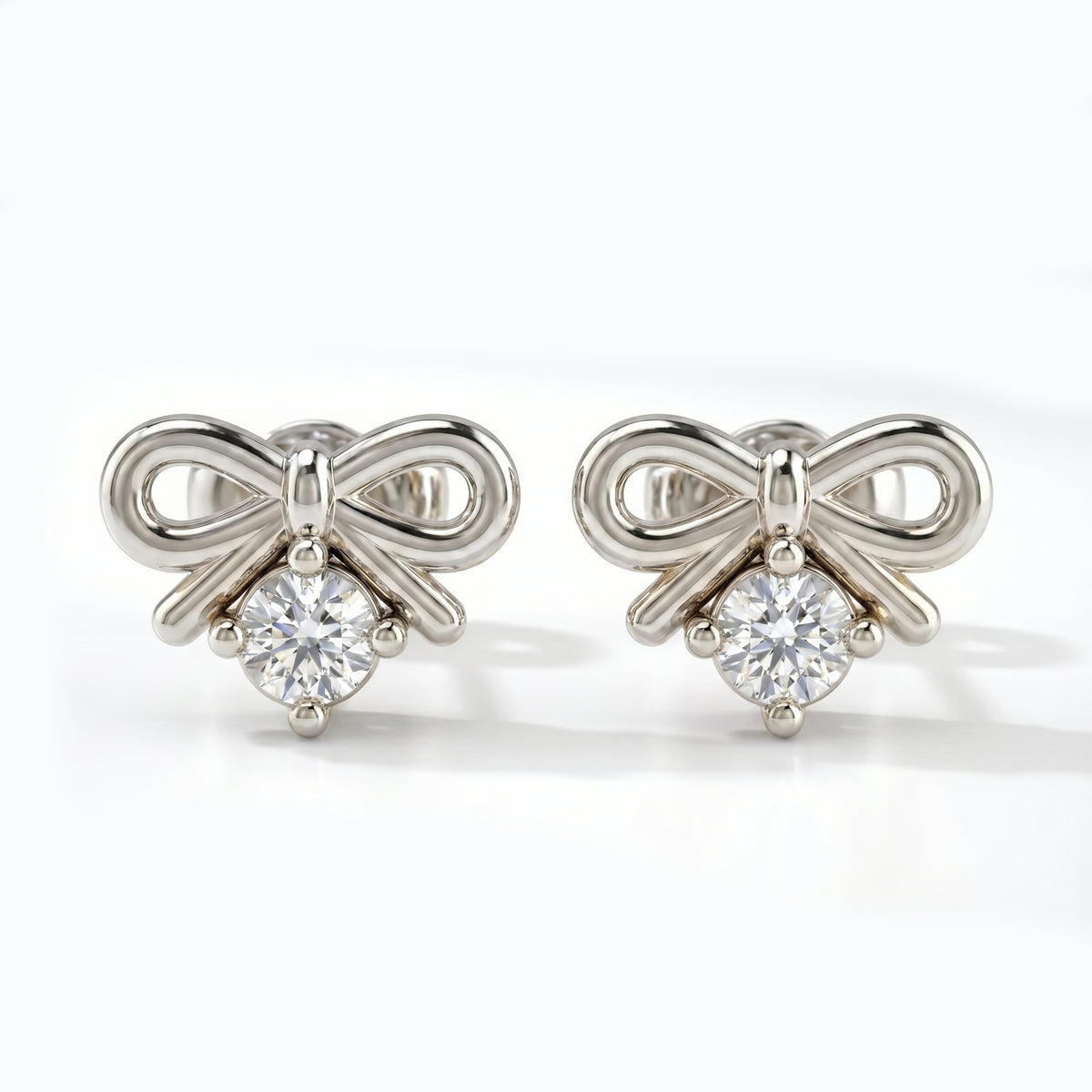 Luxury  white gold bow earrings with sparkling round stone shown at 45 degree angle on white background