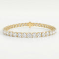 Luxury yellow gold tennis bracelet featuring brilliant Cushion-cut diamonds in a secure prong setting on white background.