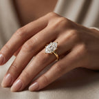 Luxury marquise diamond solitaire ring with polished yellow gold band shown in elegant lifestyle setting