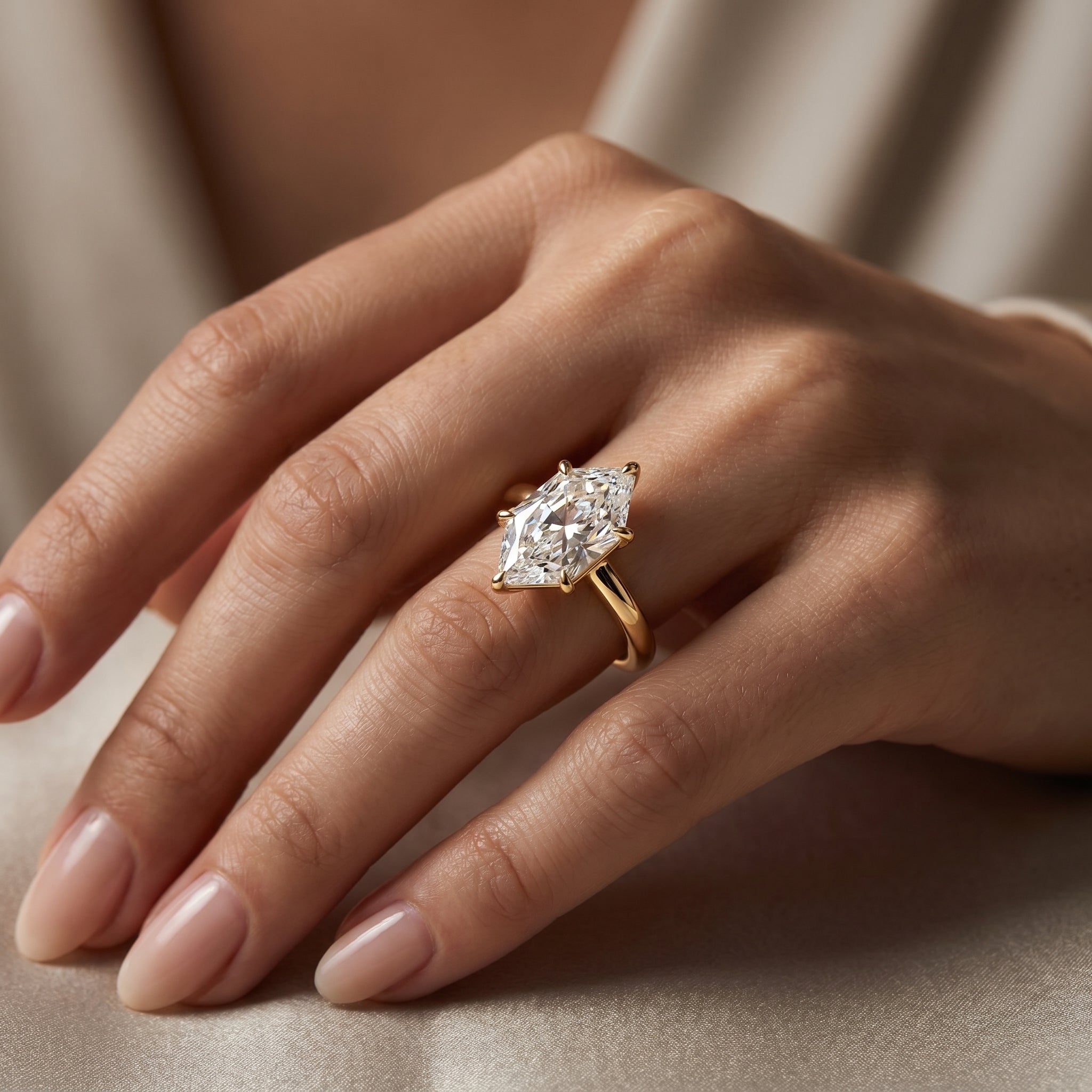 Luxury marquise diamond solitaire ring with polished yellow gold band shown in elegant lifestyle setting