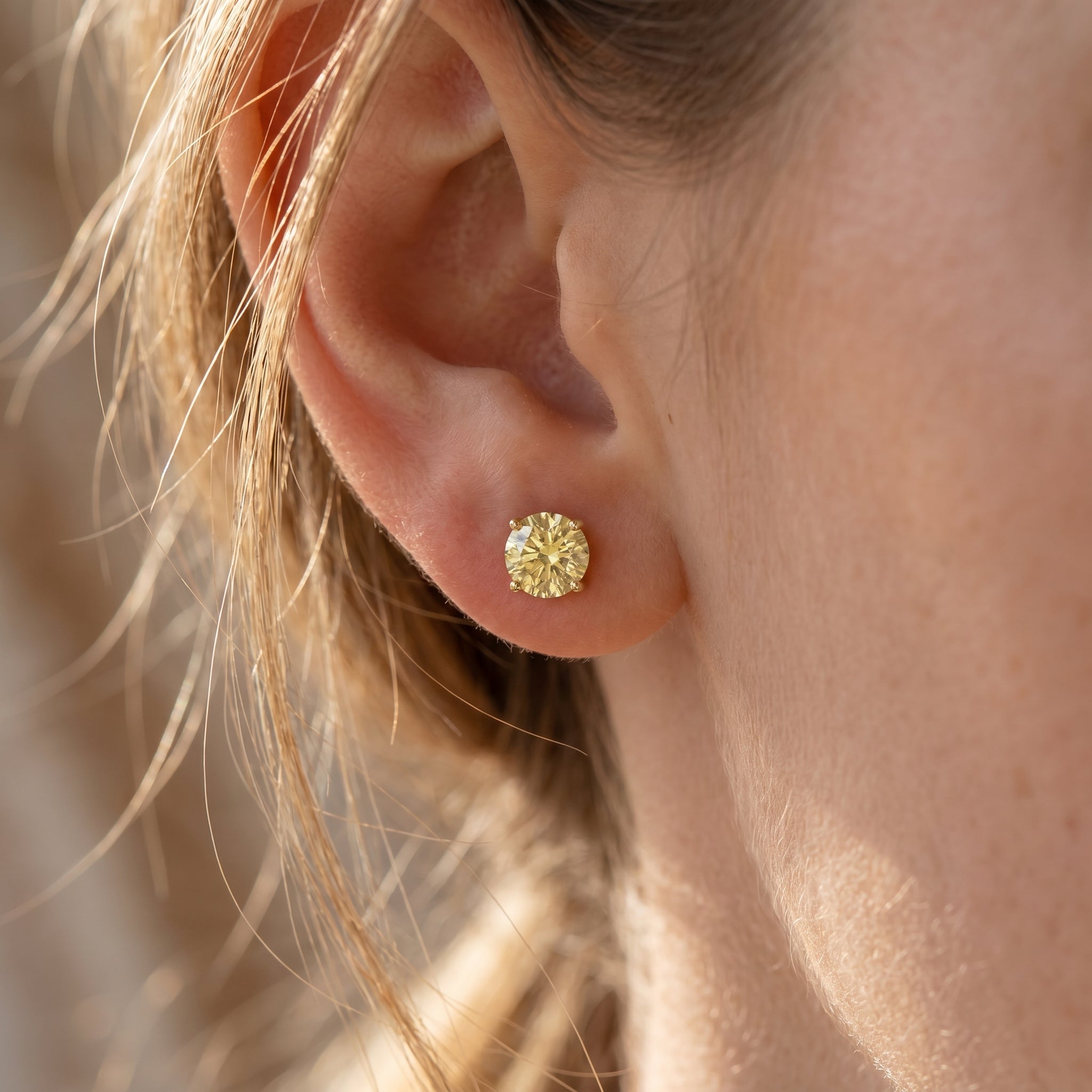 Side profile of yellow stone stud earrings showing detailed prong basket setting and craftsmanship